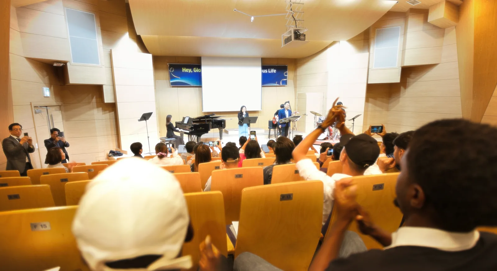 Students enjoying a performance on stage in the music hall