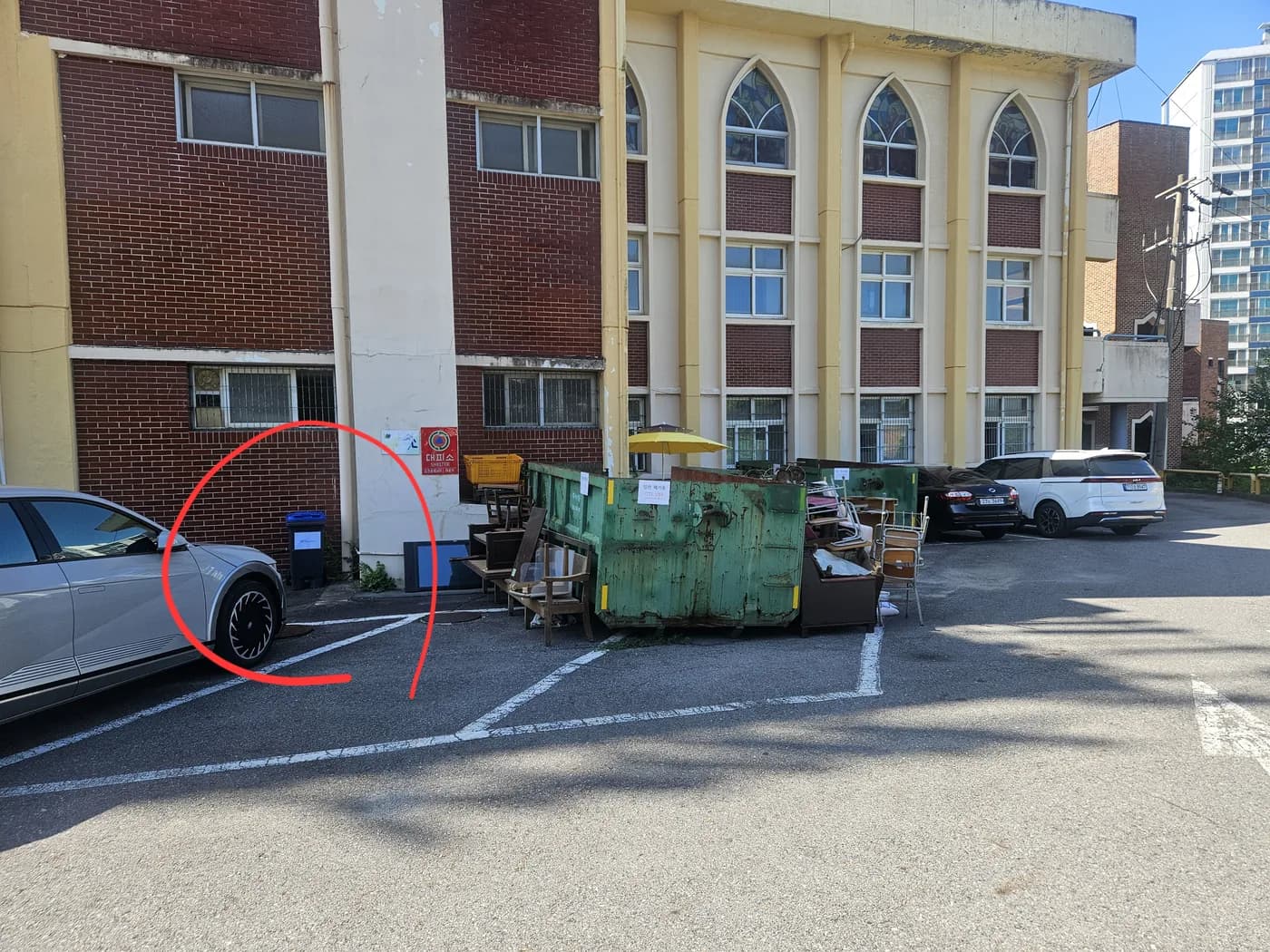 Parking area behind the dormitory; the food waste bin for international students is circled in red